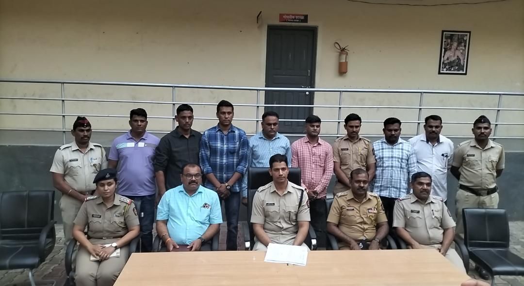 img-20260511-wa00753712372059405366985 - NewsNation Online Group photo of uniformed police officers and civilians posing in front of a building, with a table and documents in the foreground.