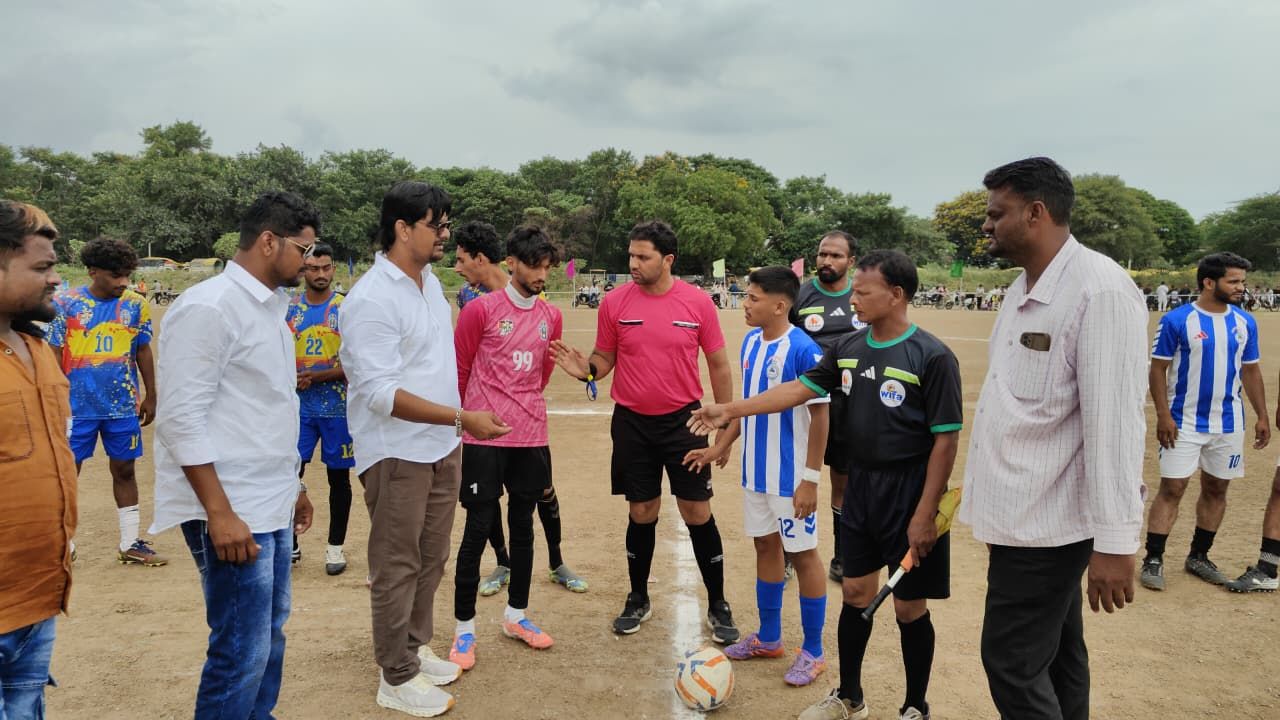 Group of players and referees shaking hands on a dusty soccer field before a match in progresshumor?