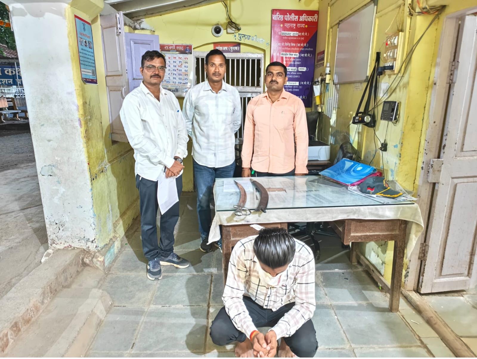 पारध पुलिस थाने में मेज पर रखी जब्त तलवारें और पुलिसकर्मियों के साथ नीचे बैठा संदिग्ध युवक