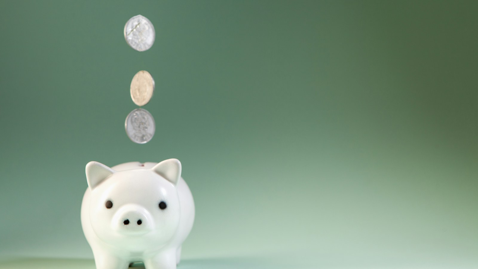Coins falling into a piggy bank; illustrative photograph for children's savings coverage
